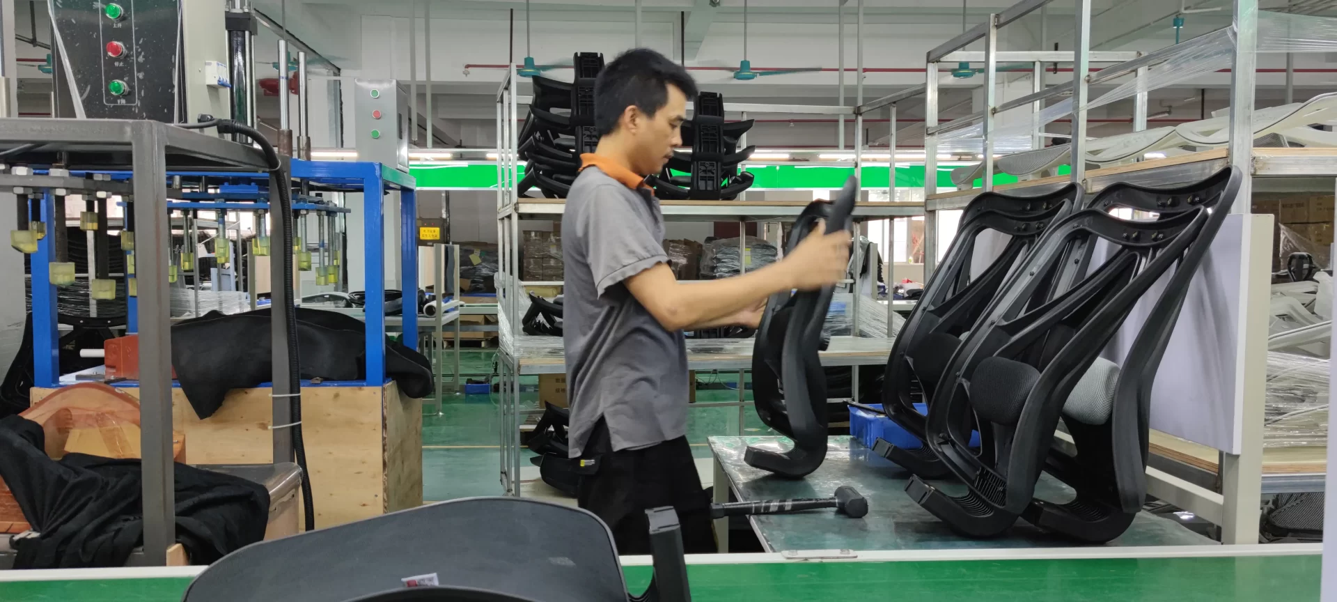 Skilled technician assembling SIHOO ergonomic chair backrests on a factory production line, blending craftsmanship with precision manufacturing.